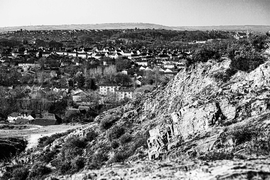 Black and white image of rural countryside town from up a hill