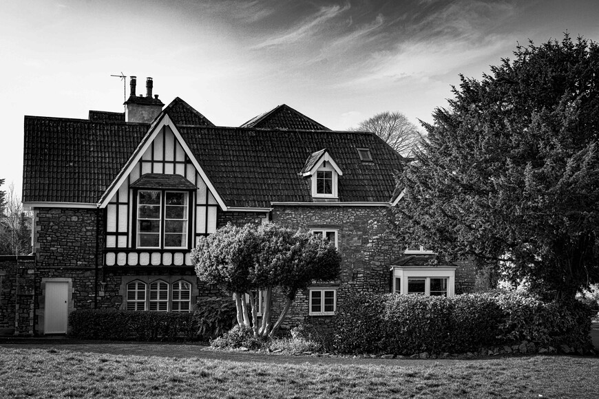 Black and white image of a large property with front lawn