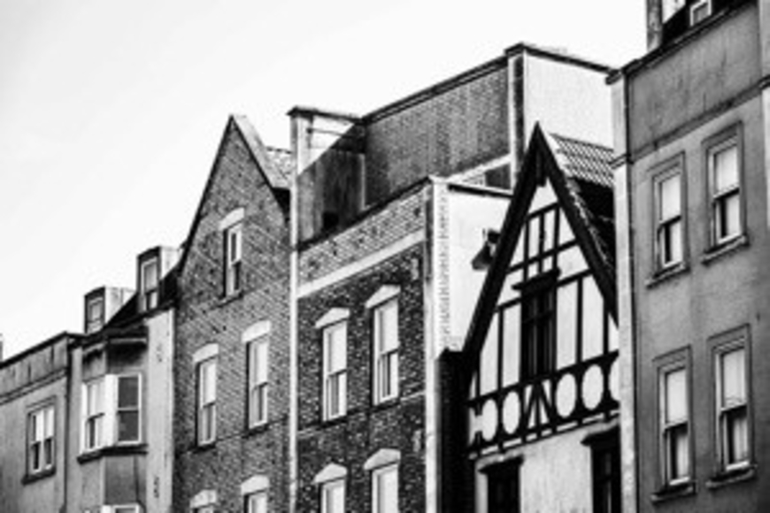 Black and white image of row of terraced houses of differing styles
